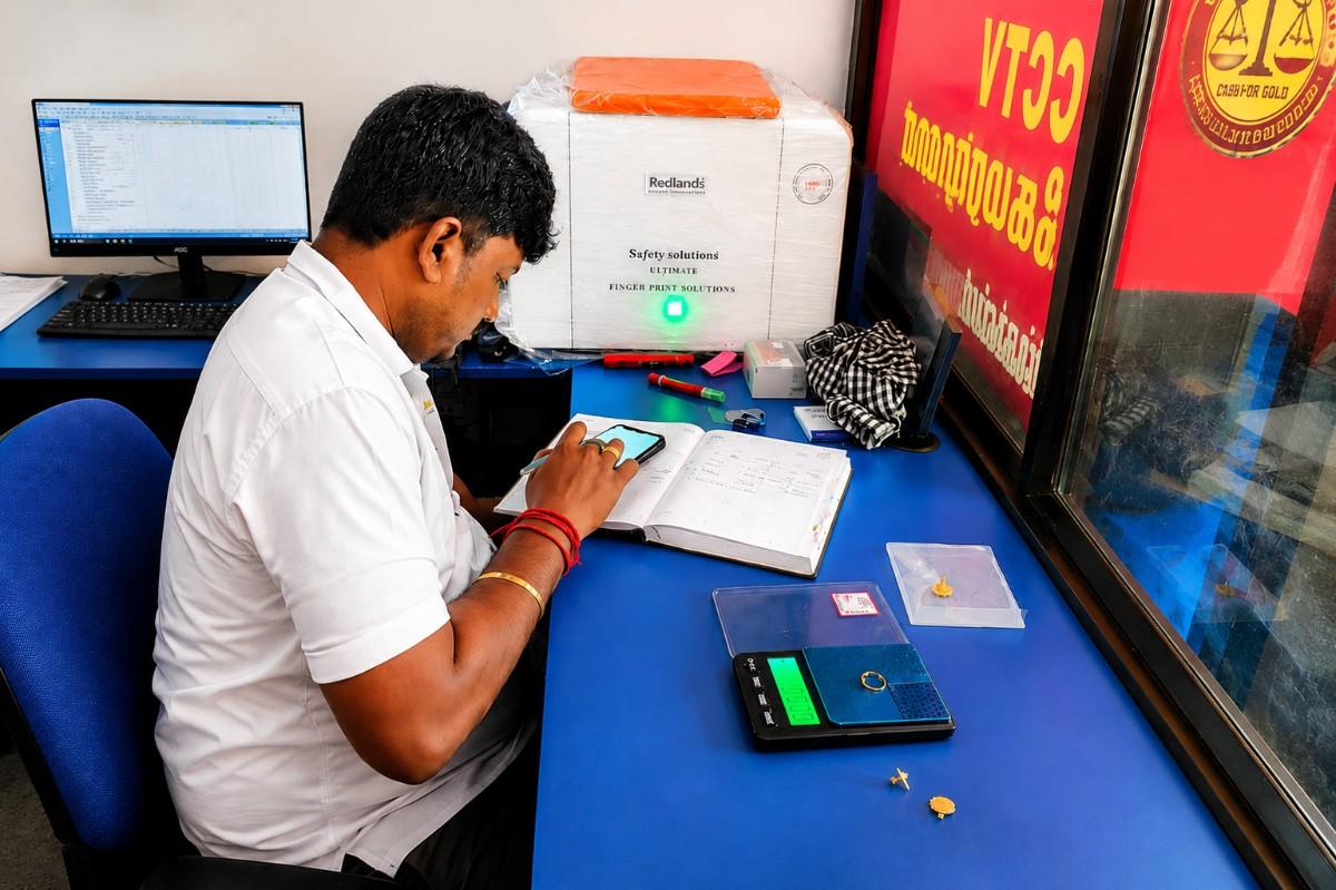 Gold valuation expert recording and assessing gold items through a secure process