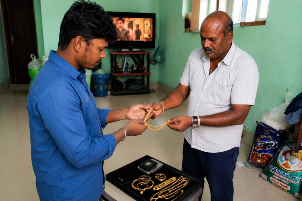 Customer and evaluator verifying gold jewellery during the cash-for-gold process